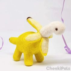 a stuffed animal that is yellow and has a purple ribbon around it's neck