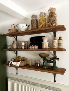 some shelves are filled with jars and other items on top of each shelf in front of a radiator