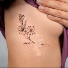 a woman's stomach with a flower tattoo on it