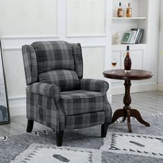 a living room with a chair, table and bookshelf on the wall next to it