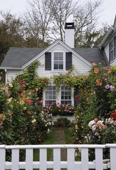 a white house covered in flowers and vines