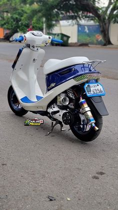 a white and blue scooter parked on the street