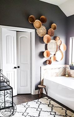 a bathroom with baskets hanging on the wall and a bathtub in front of it