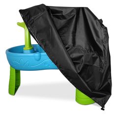 an umbrella is opened over a blue and green toy water table with a black cover on it