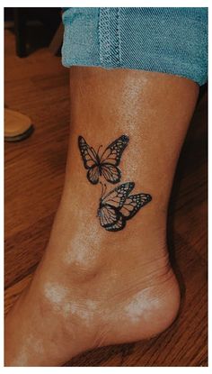 a woman's foot with two butterflies tattoo on the side of her leg,