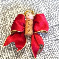 a red bow with a cork doll on it