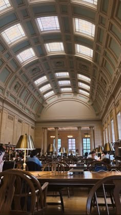 a large room filled with lots of tables and chairs next to each other in front of windows