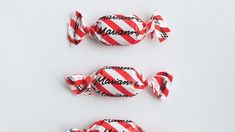 three lollipops wrapped in red and white striped paper with the word mamma written on them