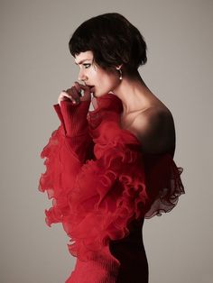 a woman in a red dress posing for the camera