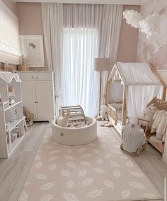 a baby's room with pink walls and white furniture