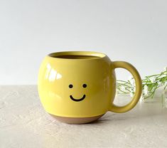 a yellow mug with a smiley face on it