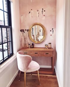 a vanity and mirror in a small room with pink walls, wood flooring and wooden floors