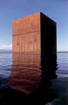 the cube is floating in the water and reflecting it's reflection on the surface