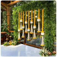 a bunch of hanging decorations in the middle of a room filled with plants and greenery