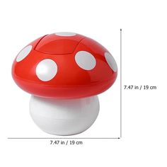 a red mushroom shaped object with white dots on it's top and bottom half