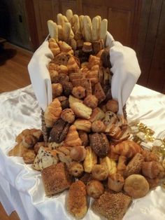 a table topped with lots of different types of breads and pastries on top of each other