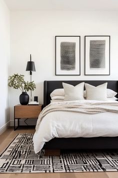 a bed with white sheets and pillows in a bedroom next to two pictures on the wall