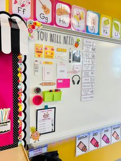 a white board with writing on it in a school room or playroom that is brightly colored and decorated