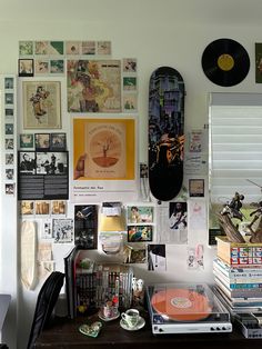 a desk with various records and pictures on the wall