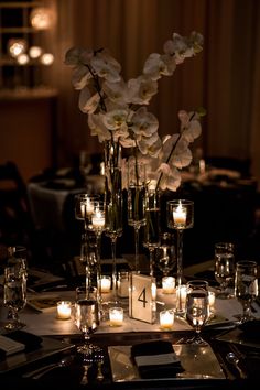 a centerpiece with candles and flowers on a table