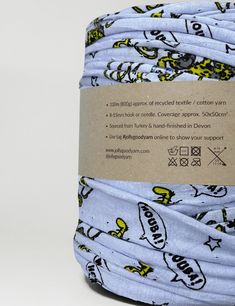 a roll of blue and yellow fabric with cartoon characters on it's back side