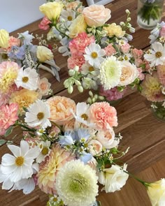 a bunch of flowers sitting on top of a wooden table