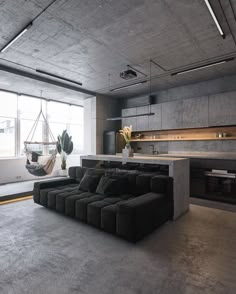 a living room filled with furniture and a hammock hanging from the ceiling