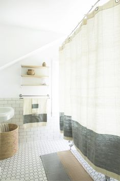 a bathroom with a shower curtain, sink and bathtub in the middle of it