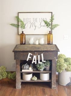 a wooden table topped with potted plants next to a sign that says, blessing the lord my son