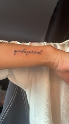 a woman's arm with the word poopied tattooed on her left arm