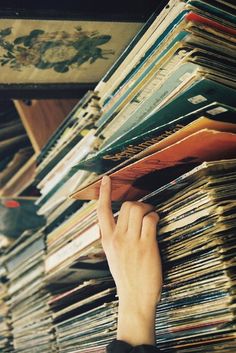 someone is picking up record records from the shelf on their iphone screen, and they are looking at them