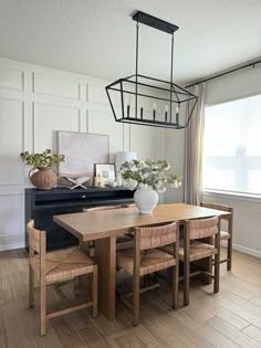 a dining room table with chairs and a piano in the background