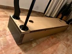 an odd looking box sitting on the floor with two legs sticking out of it's sides