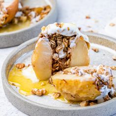 two bowls filled with food on top of a white tablecloth covered countertop and one bowl is full of granola, the other has been half eaten