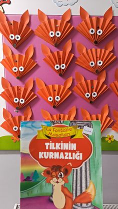 an image of a book with orange paper flowers on the cover and eyeballs in the background