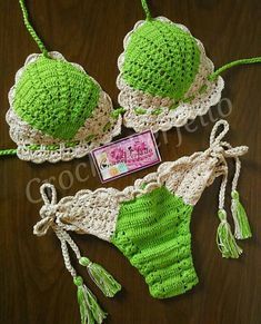 two pieces of green and white crochet swimsuits on a table with a tag