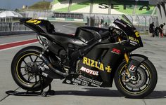 a black motorcycle parked on top of a race track