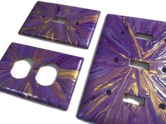 two purple and gold decorative switch plates