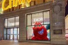 a store front with the word dior on it's display window lit up at night