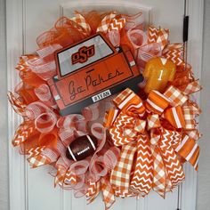 an orange and white wreath with a football on it