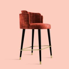 a red velvet bar stool with black legs and gold trimmings, against a pink background