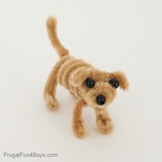 a small brown dog made out of yarn on a white surface with one eye open