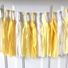 yellow and white tissue tassels hanging from a line