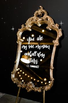 a mirror that has some lights on it in the shape of a frame with a quote