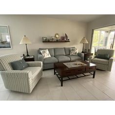 a living room with two couches and a coffee table in front of a sliding glass door