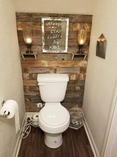 a white toilet sitting in a bathroom next to a wooden wall