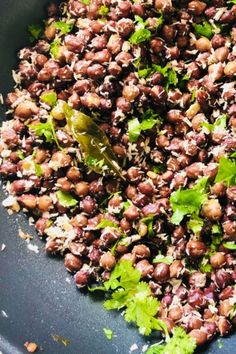 a bowl filled with beans and cilantro on top of a table