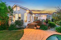 a house with a pool in the front yard at sunset or dawn, as seen from across the street