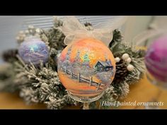 a glass ornament with an image of a house and trees in the background