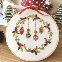 an embroidered christmas wreath with ornaments on it